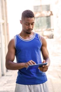 black man using tablet after a workout or exercise