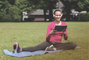 woman doing yoga with a tablet online class