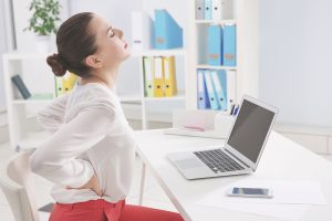 poor posture leads to back pain for people who sit in office setting