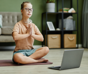 woman taking online yoga classes on tablet