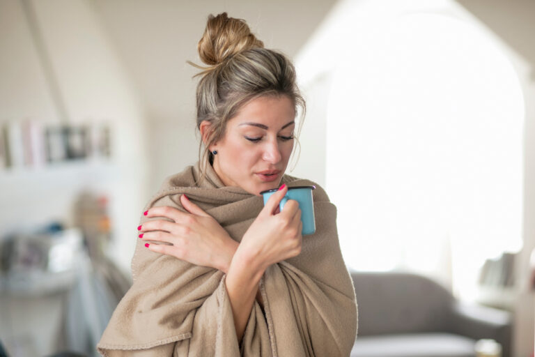 mature woman drinking bilberry tea to improve circulation and stop cold hands and feet